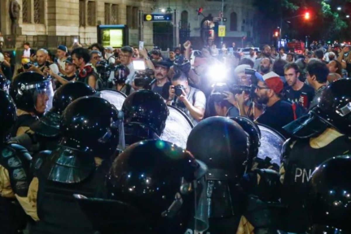 Policías hacen presencia durante una protesta de manifestantes contra el proyecto de ‘ley ómnibus’ en las inmediaciones del Congreso Nacional. Foto: Luciano González/EFE