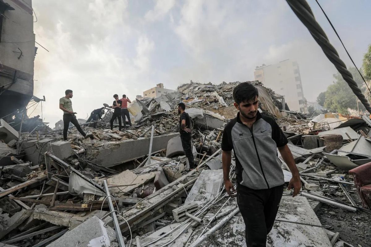 Palestinos inspeccionan los escombros de sus casas destruidas cerca de la Torre Al-Watan en la ciudad de Gaza.