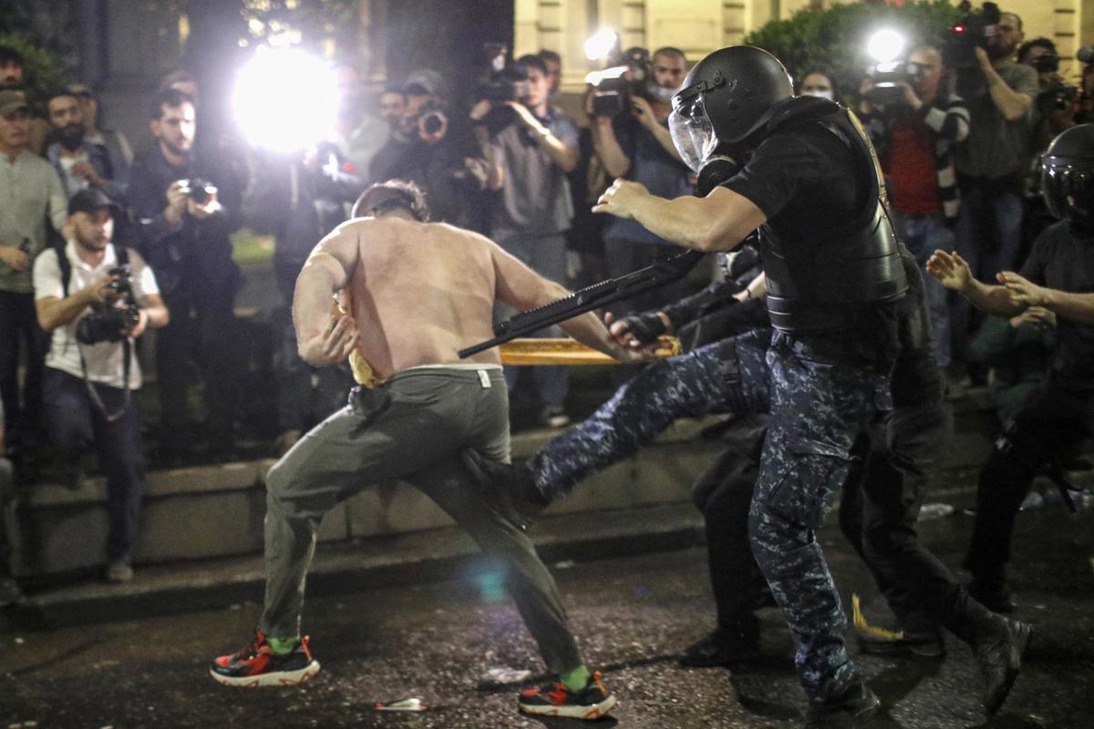 Un simpatizante del partido de oposición se enfrenta a la policía antidisturbios durante una protesta contra un proyecto de ley sobre "agentes extranjeros". Foto: David Mdzinarishvili/EFE